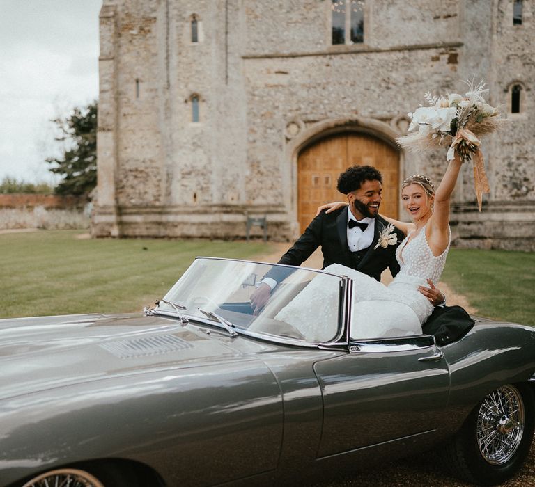 Bride and groom portrait in a classic grey wedding car for a modern luxury wedding 