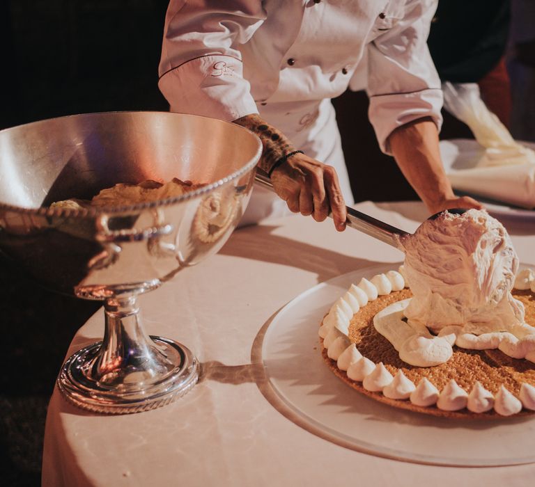 Chef creates wedding cake for bride & groom on the day of their wedding outdoors 