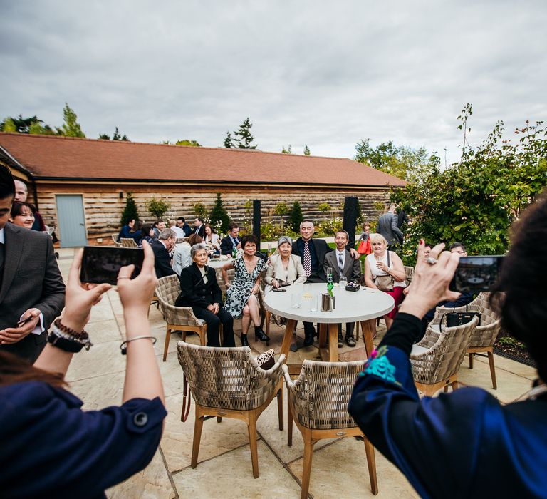 Wedding party gather for photos together outdoors