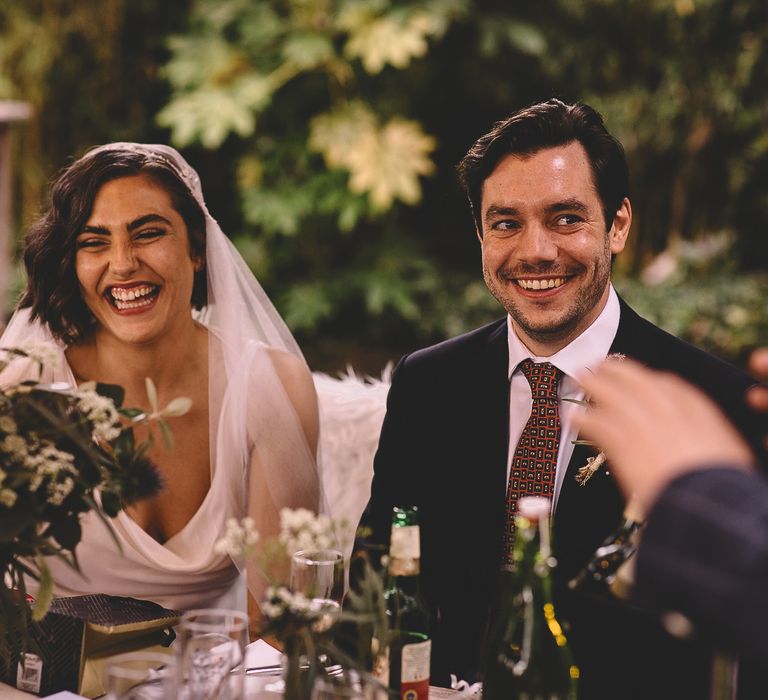 Bride and groom smiling during their pub wedding reception speeches 