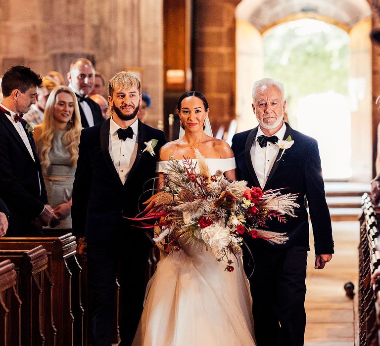 Bride walks down the aisle at church wedding ceremony