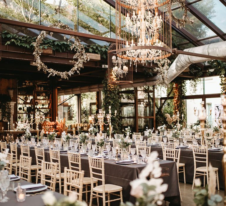 Rock chic reception venue complete with handing chandeliers and floral installations 