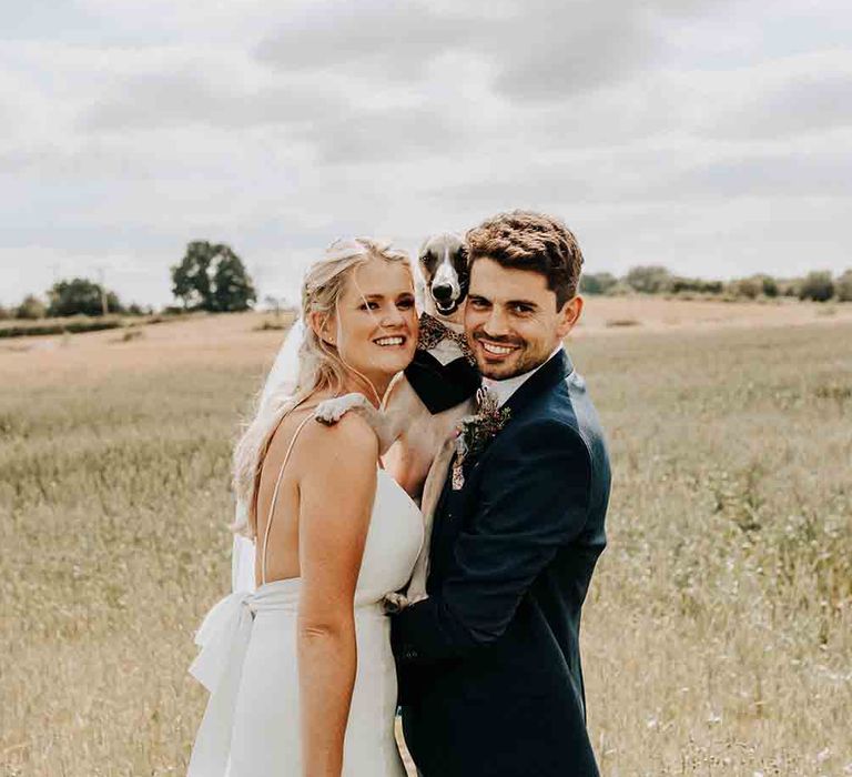 Bride and groom with their pet dog in bow tie