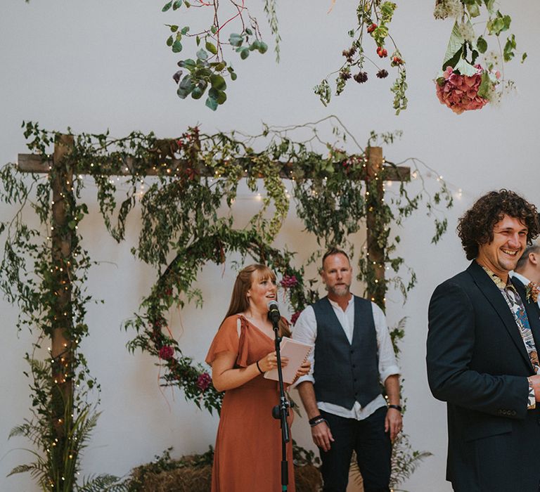 Wedding guests gather on wedding day as groom waits for his bride at the front of the aisle