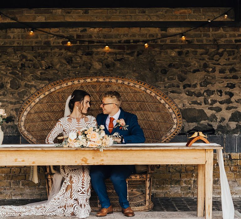 Boho wedding, Bride in long lace detailed dress with Groom in Navy suit with orange silk tie & Boutonniere 