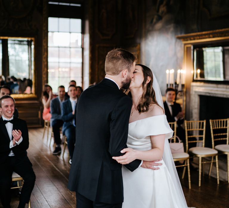 Bride & groom kiss on their wedding day in Hampton Court Palace