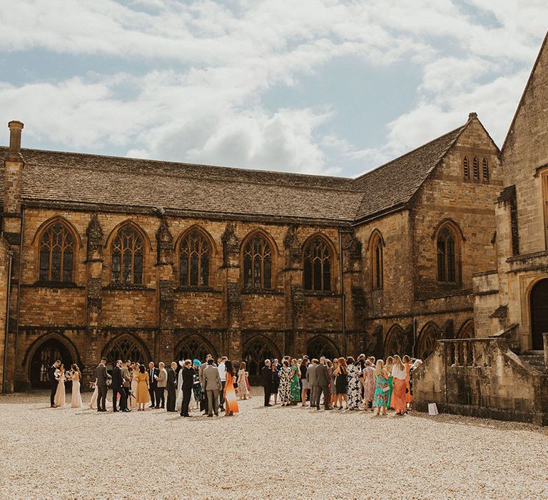 Wedding guests gather outside church on summers day for relaxed and California inspired wedding