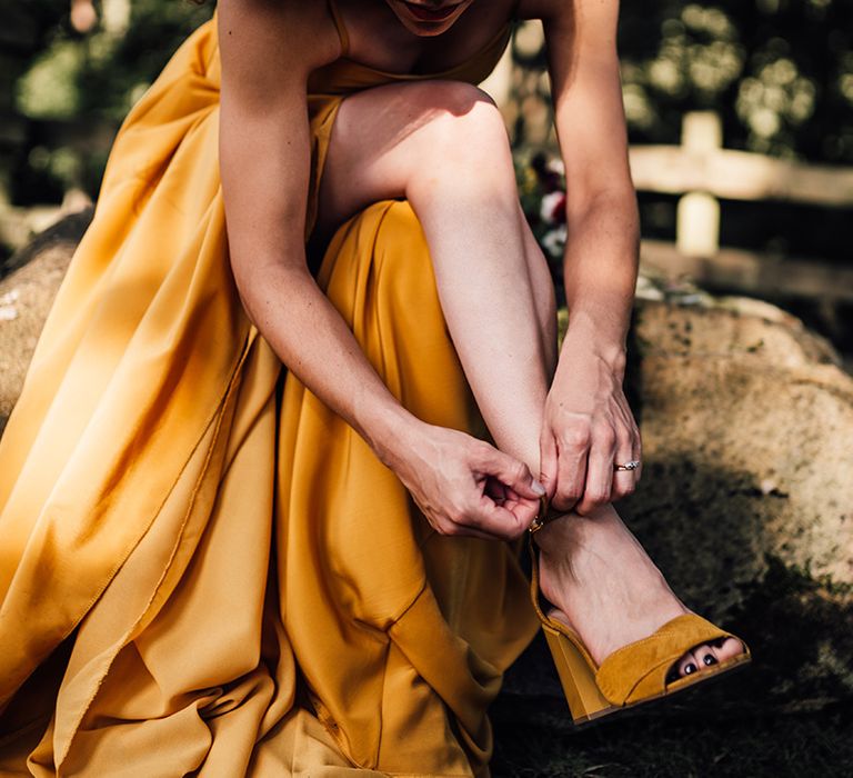 Bride does up her shoes on the morning of her wedding day