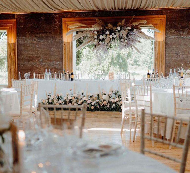 Wedding top table at Elmore Court with pampas grass and pink rose flower installation and floor flowers