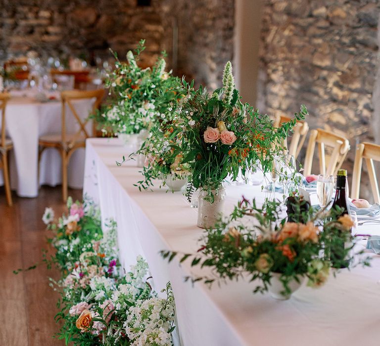 Lush top table full of colourful flowers and lots of greenery for the summer vibes and botanical wedding 