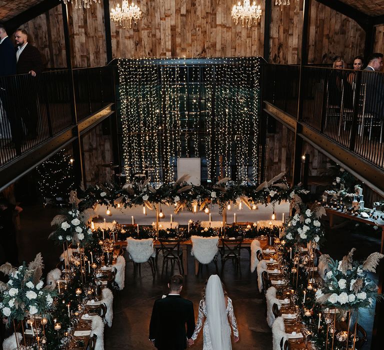 Winter wonderland fairy lights black tie wedding with fur details, white lit candles, pinecone decor