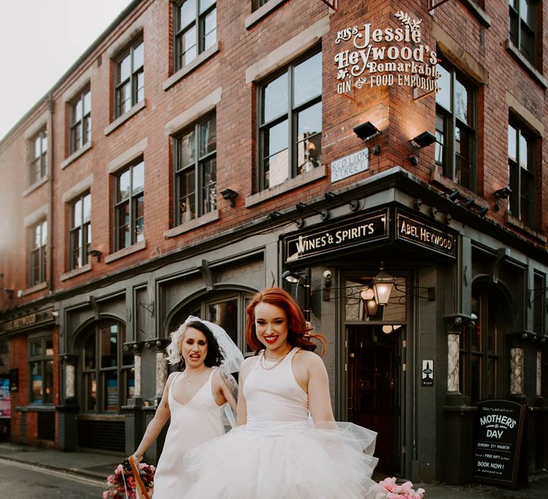 Bride in a Carrie Bradshaw tulle skirt dress with jersey top and satin slip wedding dress walking across the streets of Manchester 