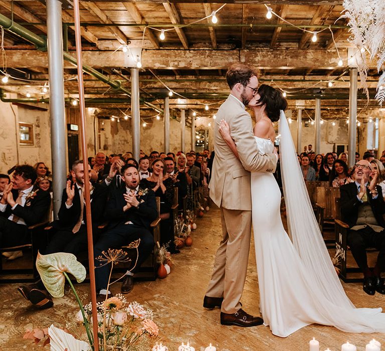 Bride and groom share their first kiss as a married couple at Holmes Mill wedding venue