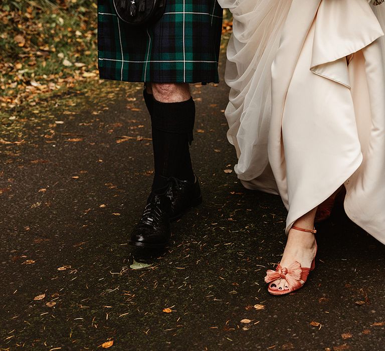 Bride's Loeffler Randall pink bow wedding shoes and groom's black shoes with knee high socks 