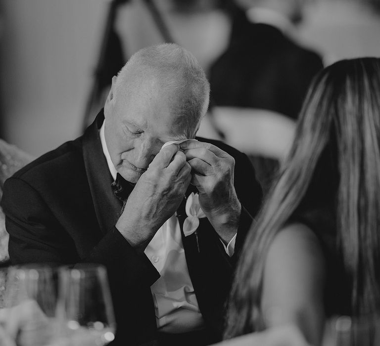 Wedding guest wipes their eyes as they listen to speeches