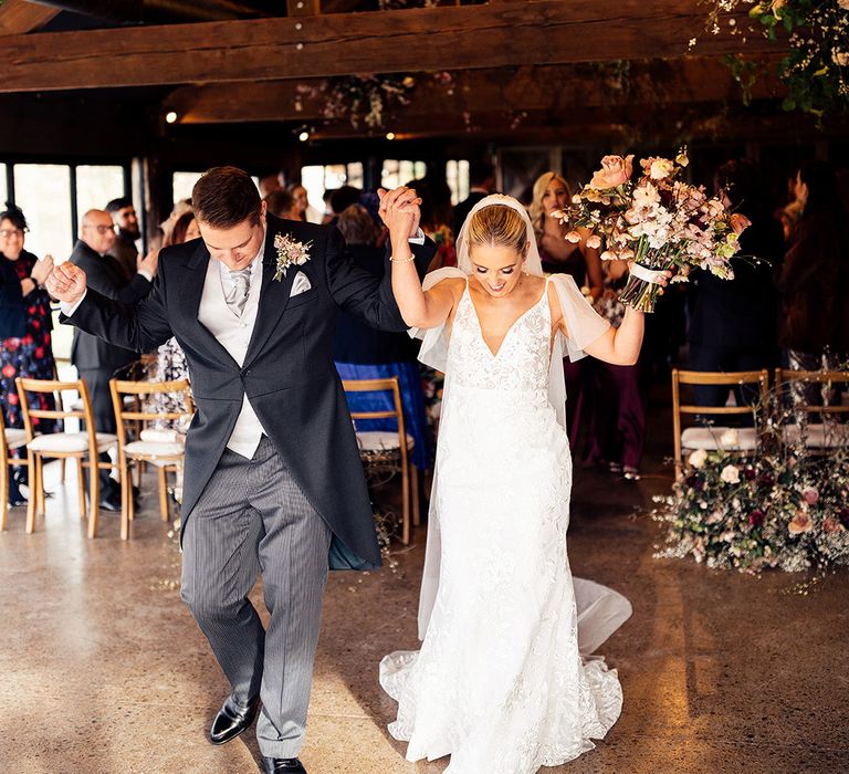 Bride and groom dance out of their wedding ceremony as they are now married