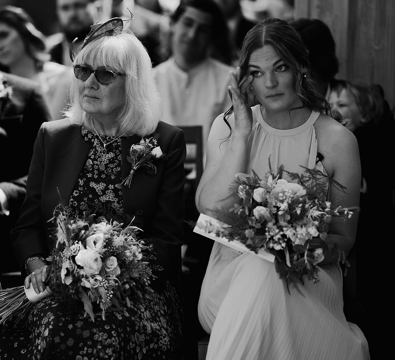 Bridesmaid wipes her eyes as she gets emotional during ceremony