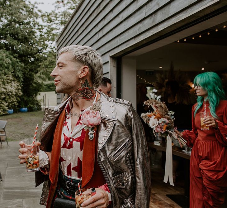 Groom wears colourful star shirt, orange velvet blazer and gold embellished leather jacket 