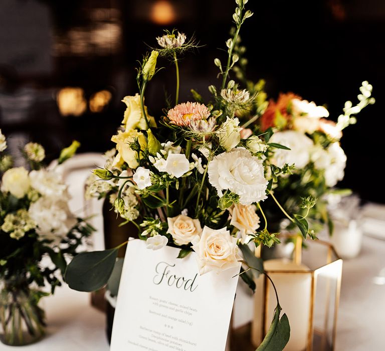 Plain and simple wedding menu card with wedding flowers decorating the tables