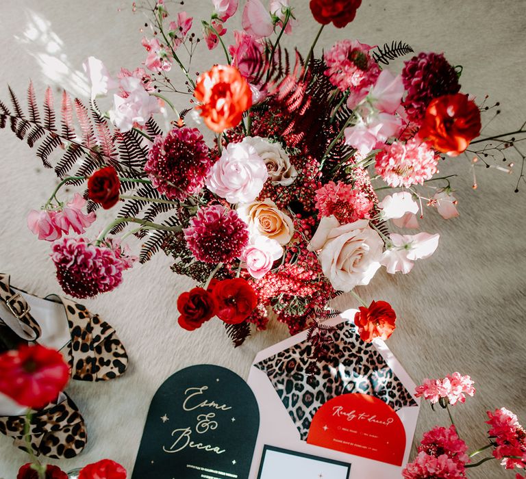 Wedding stationery flatlay with magenta pink, red and white wedding flowers 