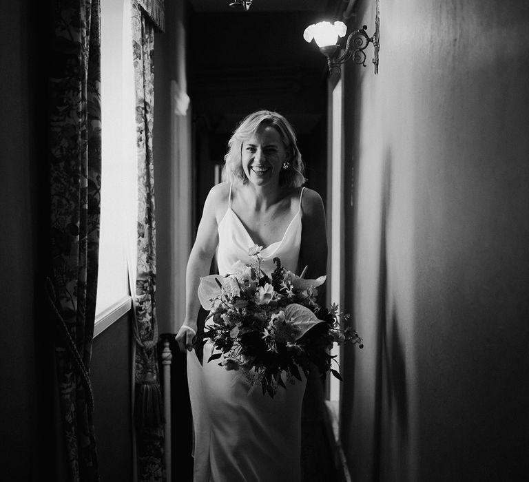 Bride wears silk slip wedding dress with cowl neck and belt 