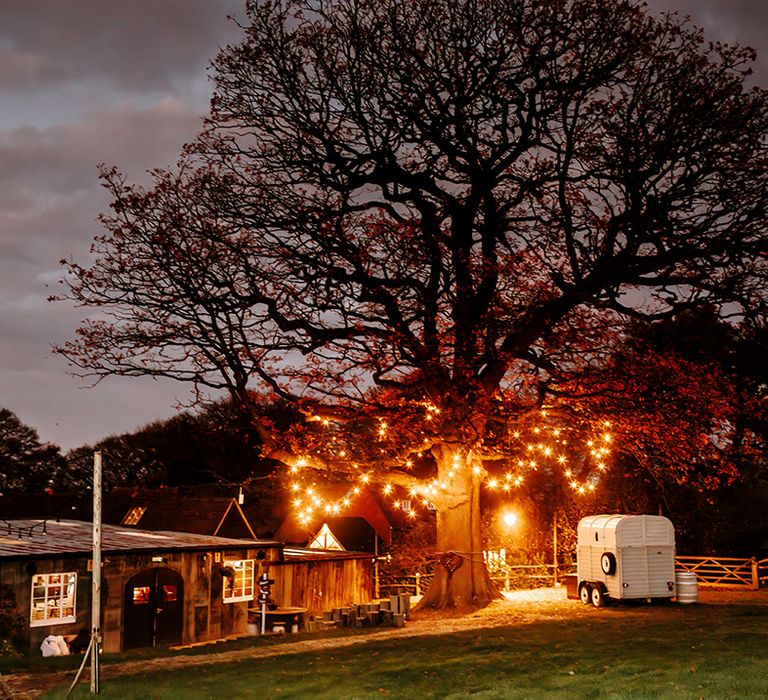 Oak Tree Barn wedding venue at night with fairy lights woven in the trees 