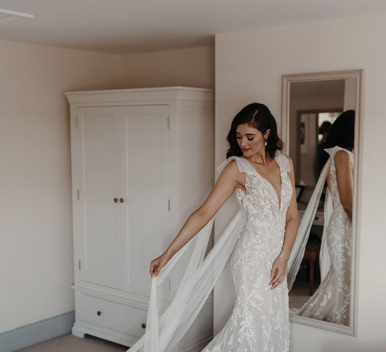 Bride wearing a Mia Sposa fitted flower embellished wedding dress with bow straps and watteau train 