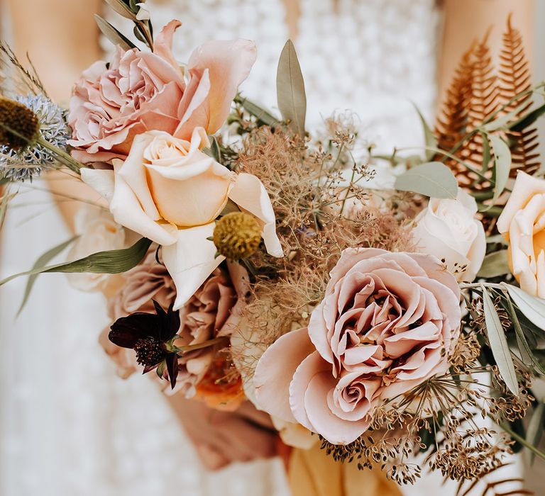 Pink rose autumnal bridal bouquet for the rustic wedding with dried grass 