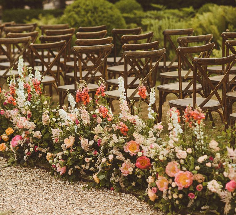 Long row of wedding flowers with pink, orange, and white wedding flowers including peonies, foxgloves, and other bell flowers