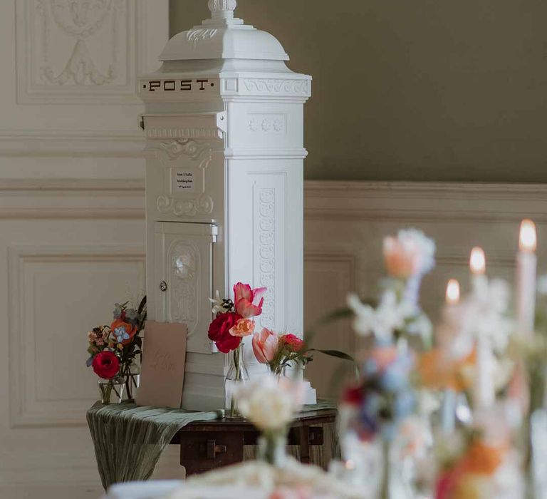 Large white post box wedding decoration by spring wedding tablescape with pastel colours on ivory wedding table cloth 