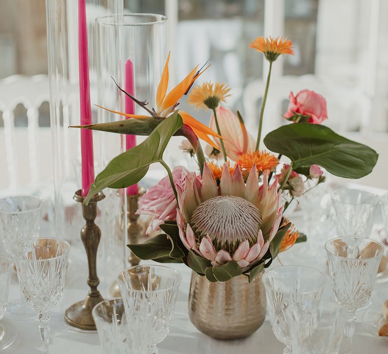 gold vase centrepiece arrangement filled with a pink protea flower