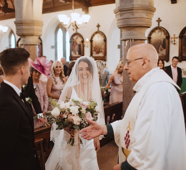 Catholic wedding ceremony with the bride and groom in traditional black tie attire 