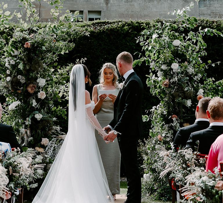 Bride wearing Aleena Lena wedding gown standing with groom at the outdoor ceremony 