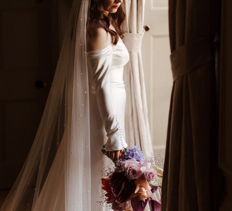 Bride wearing long sleeve off the shoulder wedding dress and veil 