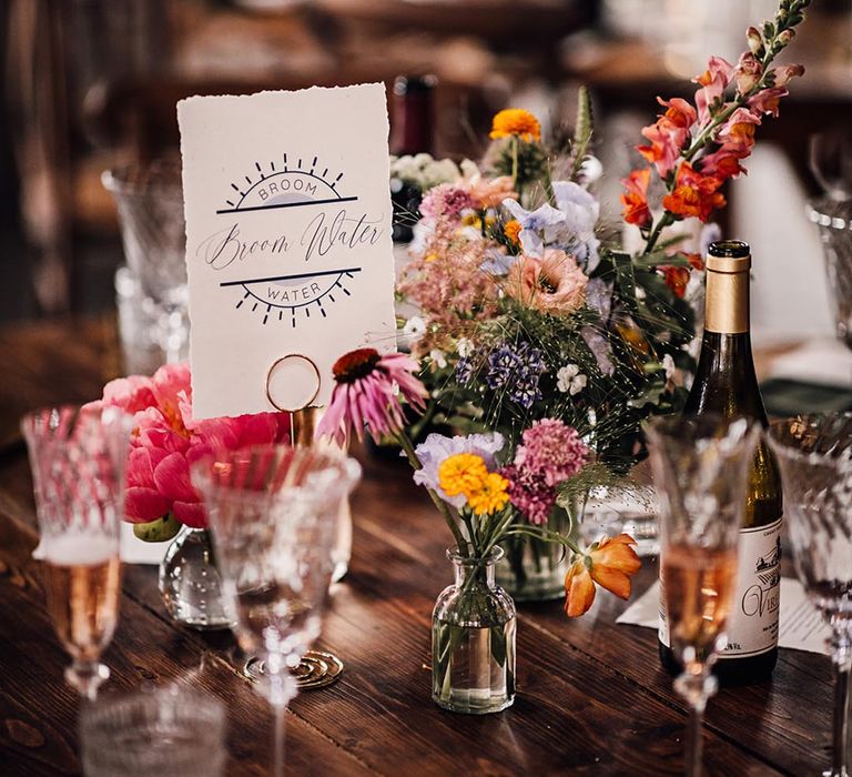 Wedding table name sign with colourful wedding flowers 