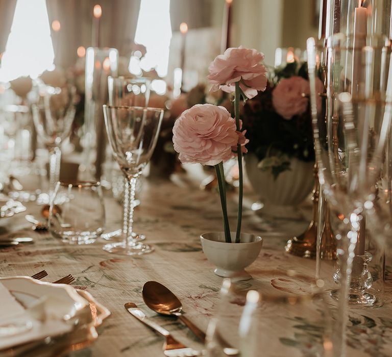 Pastel pink flowers in bud vases on the wedding tablescape 