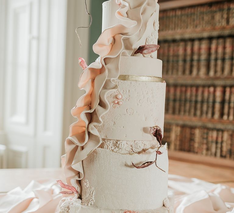 Unique iced white wedding cake with pastel decorations 