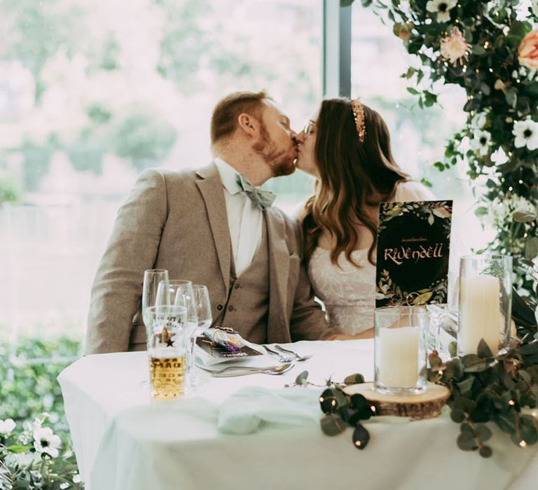 The bride and groom share a kiss at their wedding breakfast 