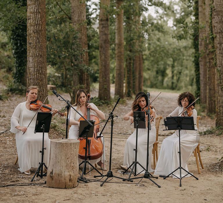 Sting quartet in all white outfits at outdoor wedding 