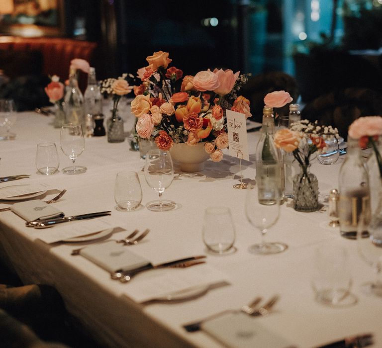 Minimalist wedding table decorations with pink and pastel neutral bud vase flower arrangements 