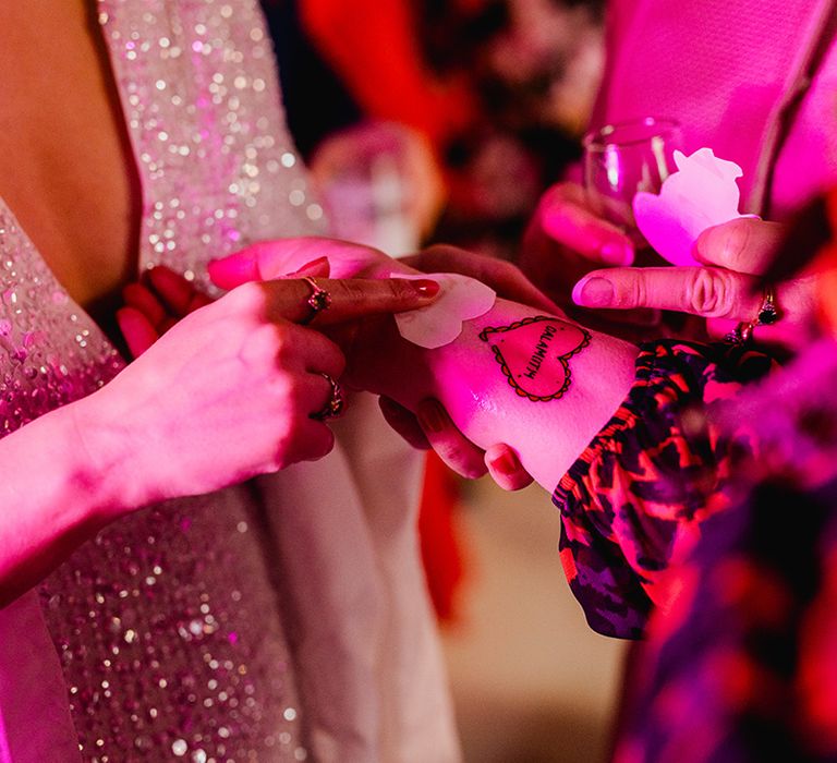 Bride giving out wedding temporary tattoos to guests for entertainment 