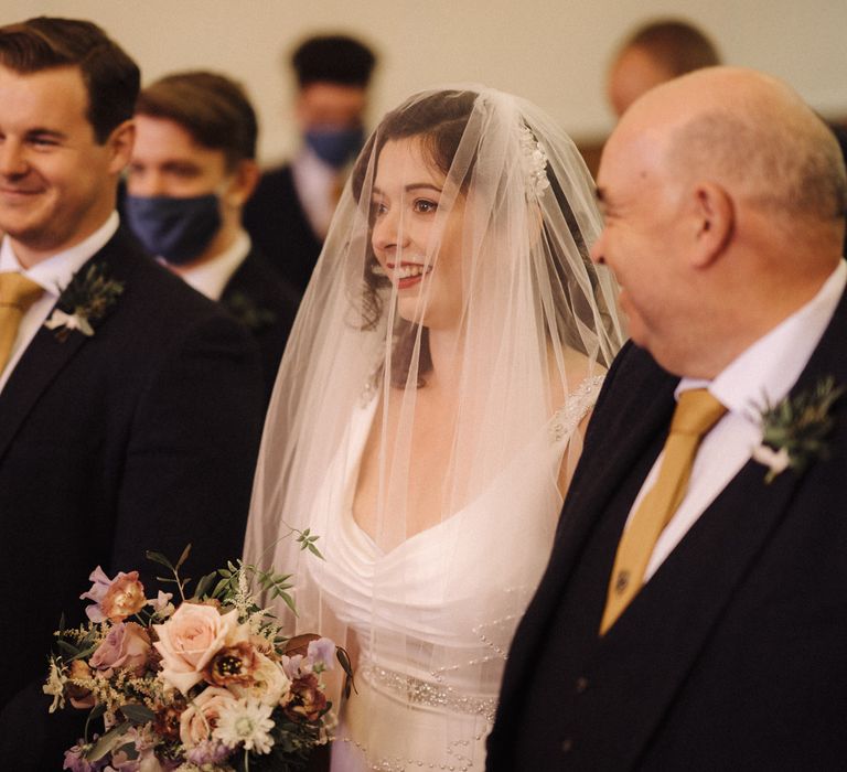 Bride & groom stand with wedding party in the Chapel 