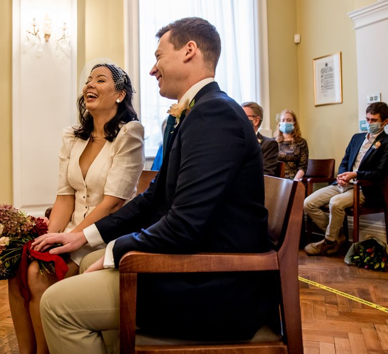 Bride and groom laughing during Chelsea Town Hall wedding ceremony 