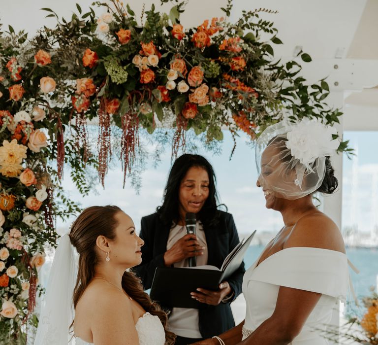 Bride and bride holding hands during the same-sex ceremony 