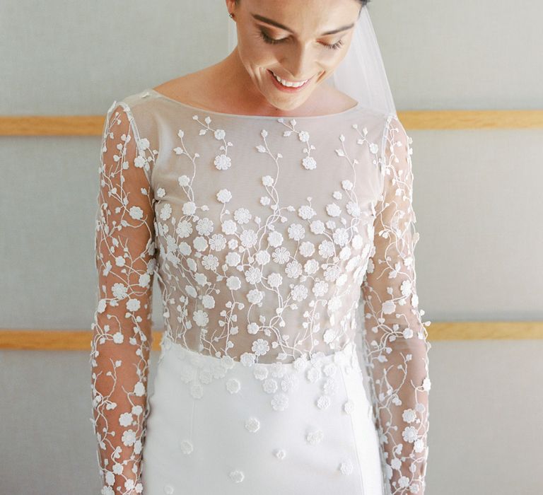 Dark haired bride wears golden floral headdress and an embroidered lace wedding gown