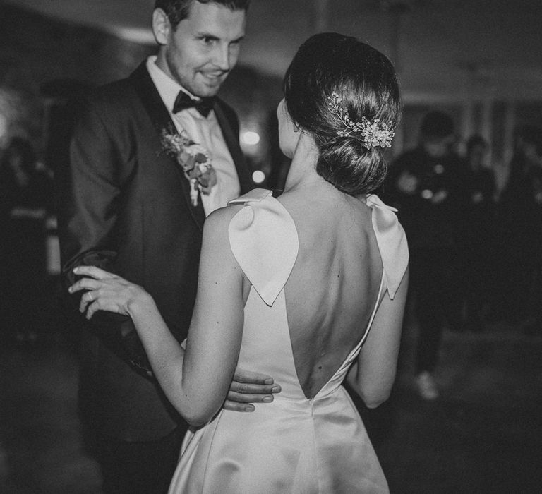 Bride in white Jesus Piero gown dances with groom in black Tiger of Sweden tuxedo at German wedding