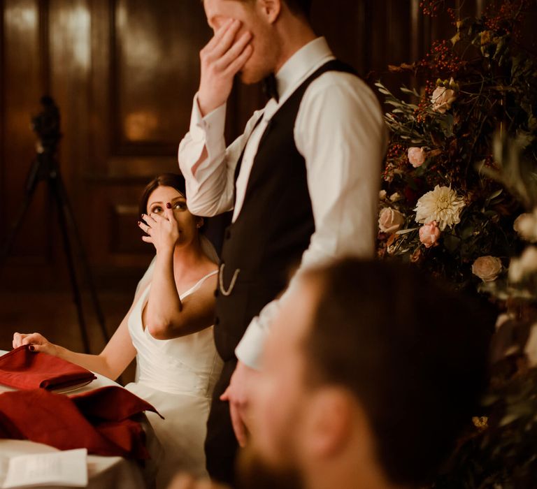 Bride and groom crying during wedding speeches 