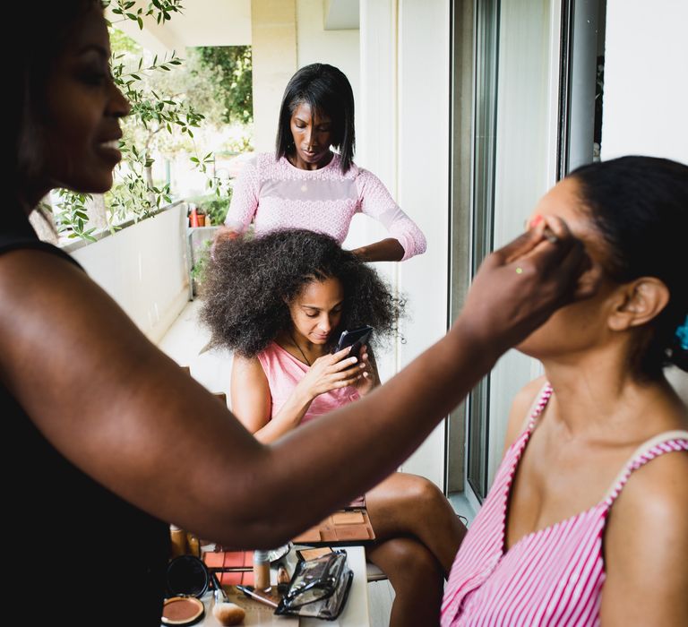 The bride with her bridesmaids having her afro hair combed and styled