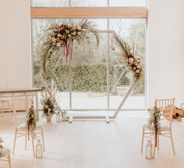 Intimate wedding with wooden altar decorated in red and green wedding flowers 