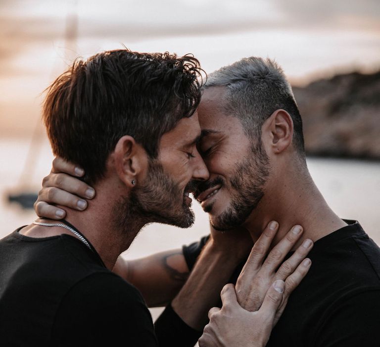 Grooms go in to kiss one another on the beach of Ibiza